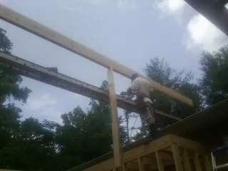 Carpenter setting a ridge beam over a new addition frame — Ice Dam Removal by Roofing Brothers in Lemoyne