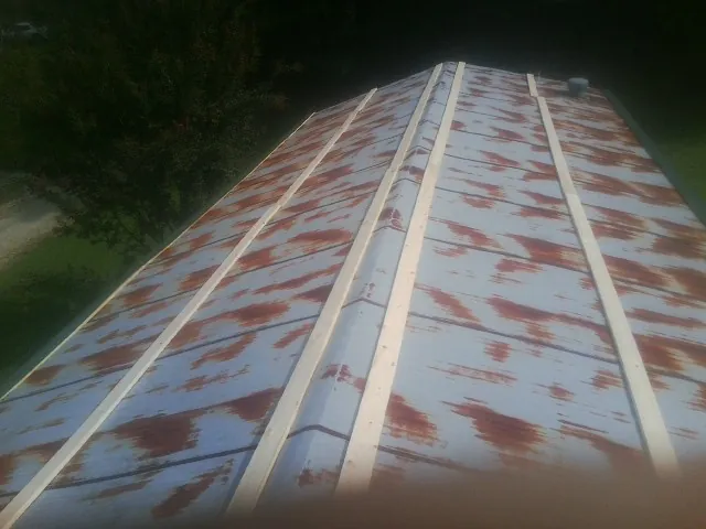 Rusted metal roof panels with new wood purlins before replacement — Storm Damage Roof Repair in Lemoyne by Roofing Brothers