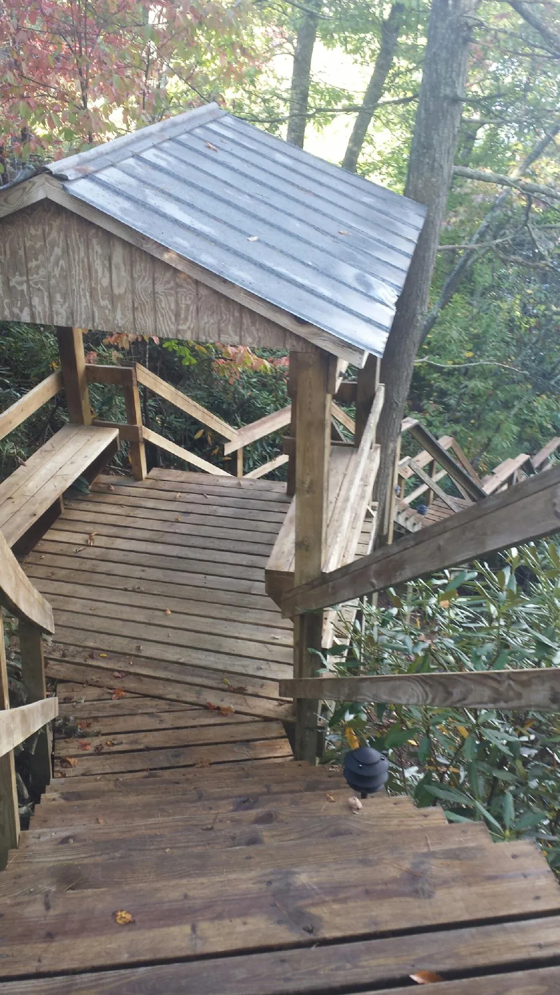 Metal roofed shelter over wooden steps on a wooded walkway — Skylight Repair & Installation work by our crew in Lemoyne