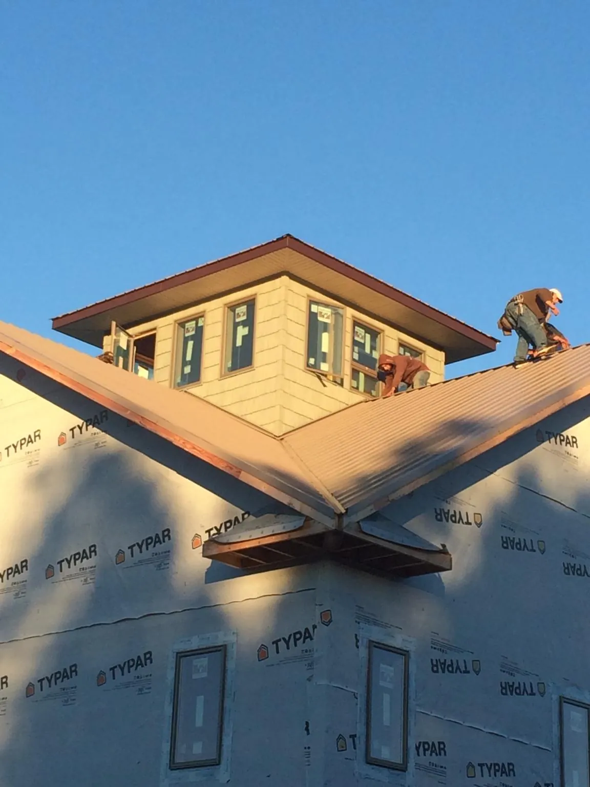 Roofers working around a rooftop cupola on a new metal roof at sunset — Roof Waterproofing in Lemoyne by Roofing Brothers